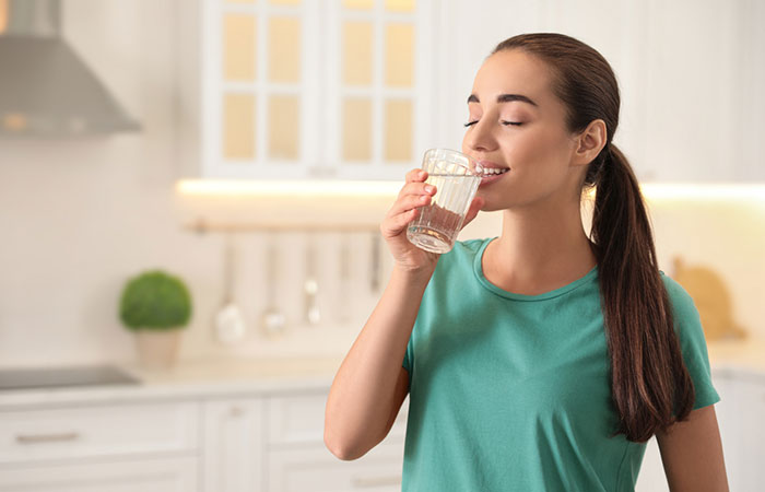 Woman drinking water to flush kidneys naturally