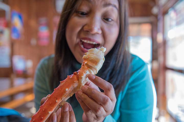 Woman eating a king crab