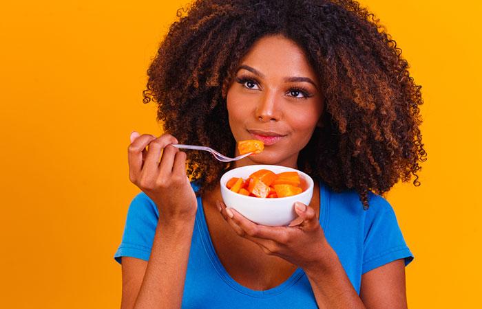 Woman eating papaya for weight loss