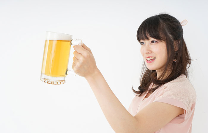 Woman holding a glass of beer for her hair
