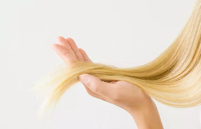 Woman holding her bleached hair