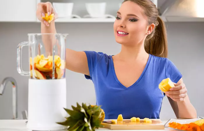 Woman making fresh pineapple juice to stay healthy