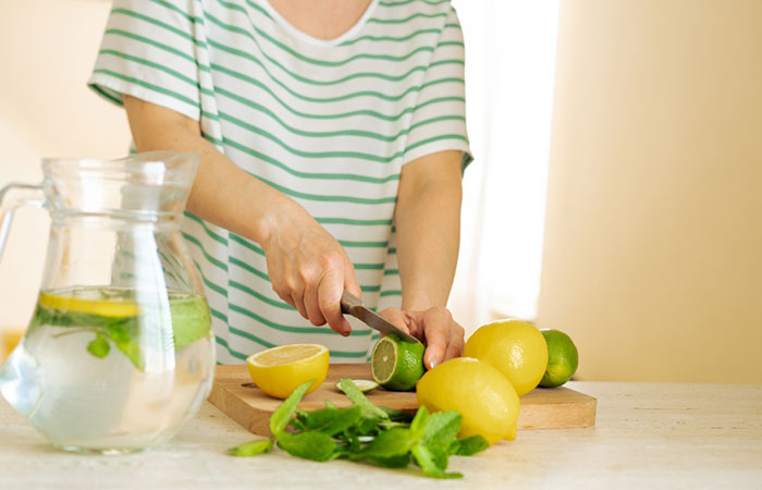 Woman preparing detox water with natural ingredients at home