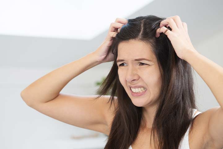 Woman scratching her itchy scalp in frustration