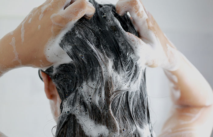 Woman shampooing hair before mousse application