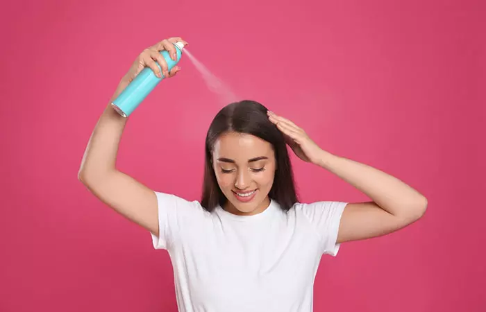 Woman spraying dry shampoo