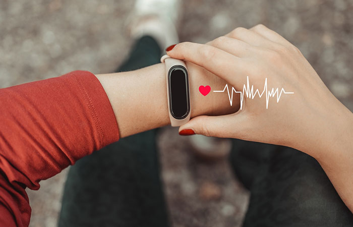 Woman tracking heartbeat on fitness tracker