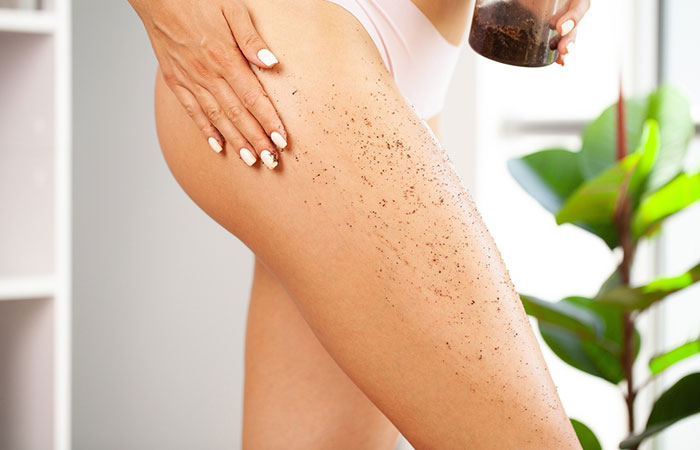 Woman using castor oil and sugar scrub on stretch marks