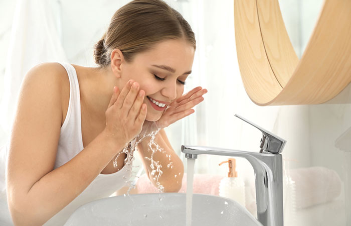 Woman washes her face to avoid acne 