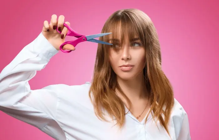 A woman cutting bangs