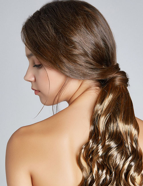 Beachy waves with low knotted ponytail hairtsyle for long hair
