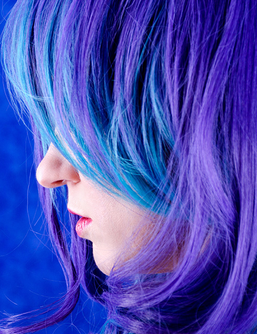 Bouncy blue and purple curls with side swept bangs layered hairstyle