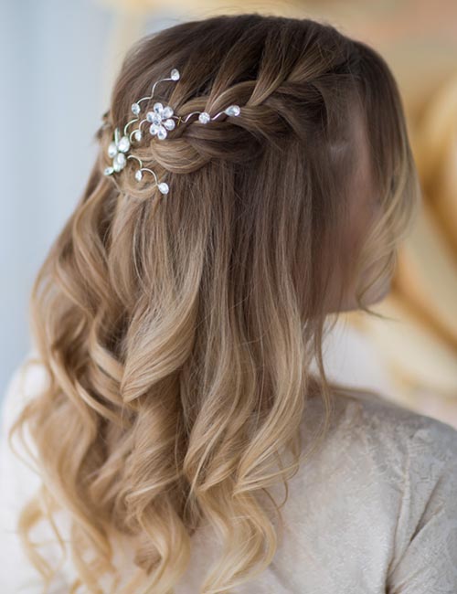 Curly blonde balayage hair braided in half crown