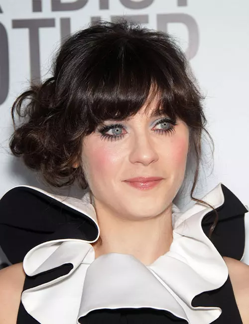 Zooey Deschenael with loose side bun and thick bangs
