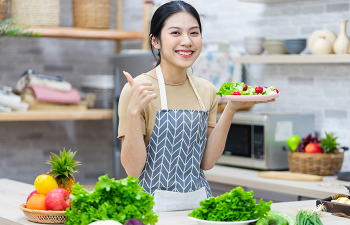 Asian woman making salad