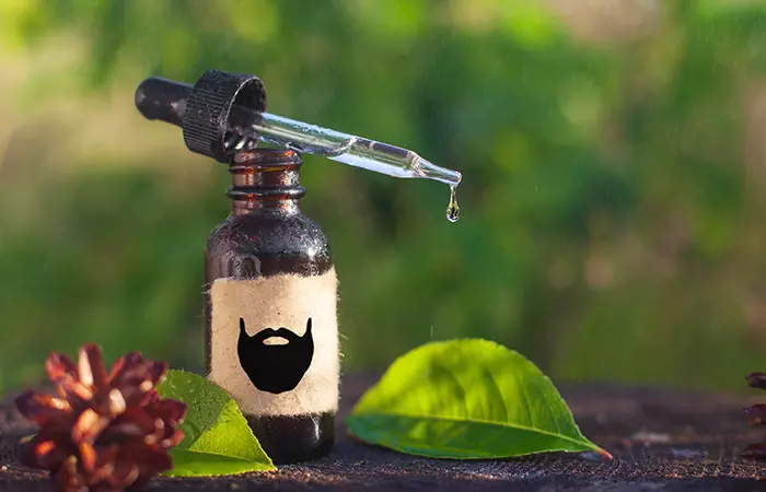 Beard oil in a small bottle with a dropper kept in a natural environment