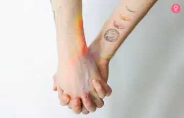 Close up of held hands with one of them flaunting a moon phase mother son tattoo
