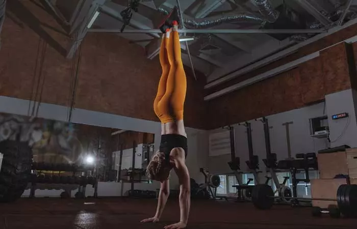 Woman doing a handstand for EMOM Workouts