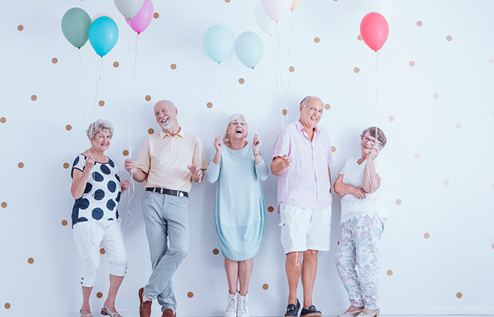 Elderly people holding balloons