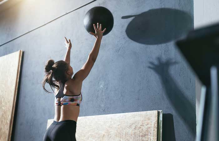 Woman training with a wall ball for EMOM Workouts