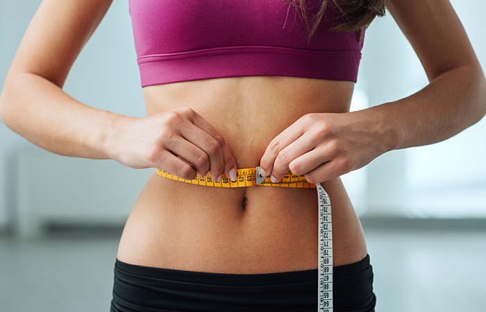 Following the runner’s diet helps a woman measuring her waist lose weight