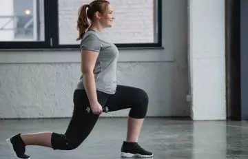 Woman performing lunges for full body EMOM Workouts