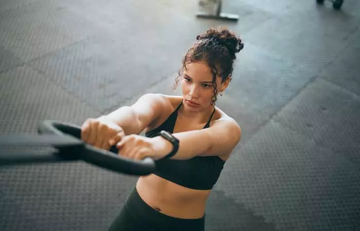 Woman doing ring dips for EMOM Workouts in the gym