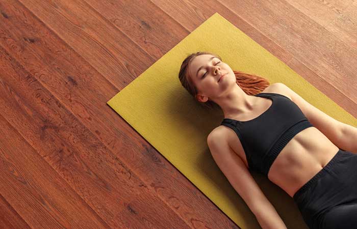 Woman lying on yoga mat feeling relaxed after sound bath.