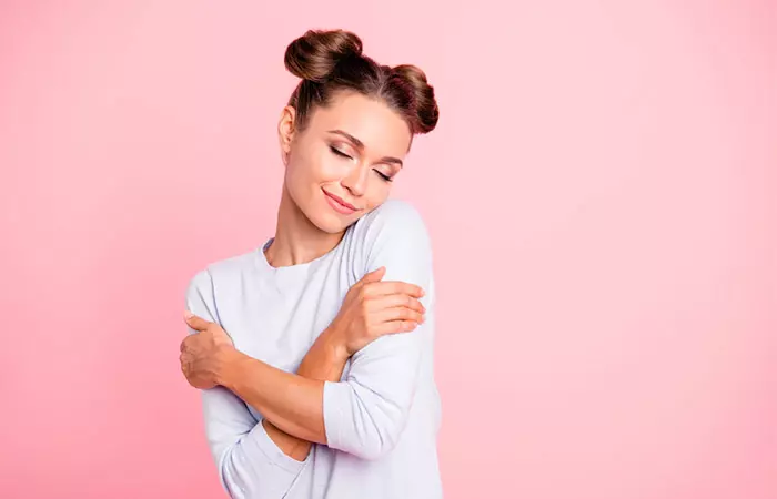 Happy woman hugging herself is a step to avoid being codependent in a relationship