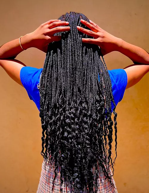 Model spotting long curly-ended knotless braids