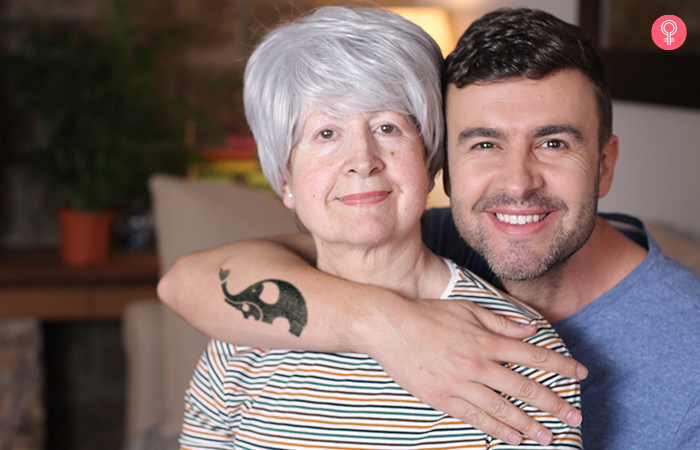 Man with a cute mother and baby elephant mother son tattoo gives his mother a back embrace