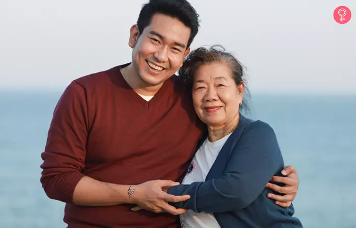 Man with paper crane mother son tattoo on hand taking selfies with his mother