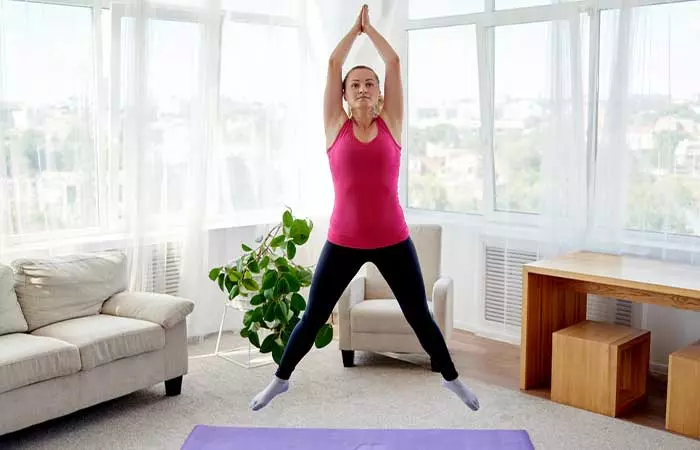 Woman doing jumping jacks for bodyweight EMOM Workouts