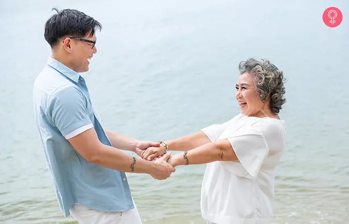 Mother and son with leaf vine bands for mother son tattoos holding hands at the beach