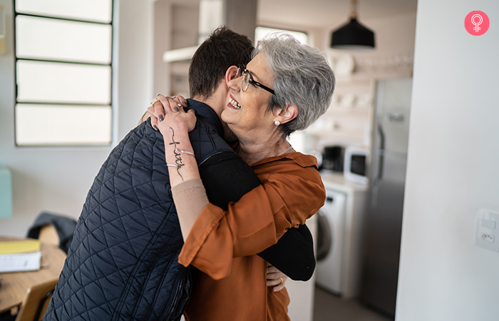 Mother with faith calligraphy mother son tattoo on her arm hugs her son