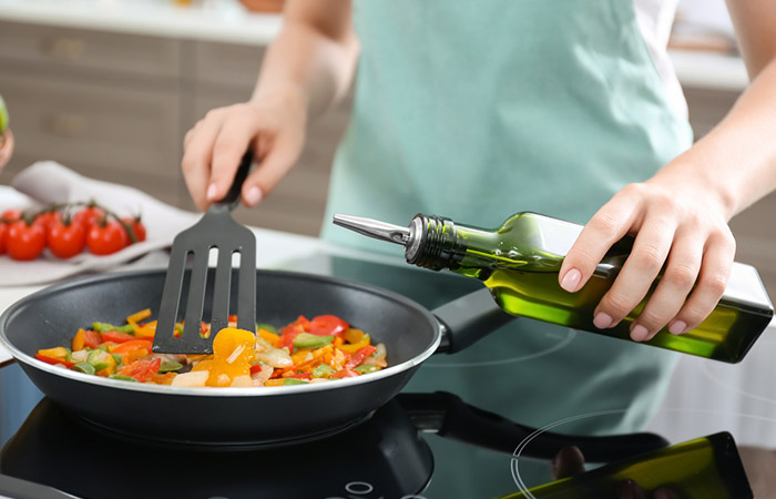 Woman using olive oil for sauteing and stir-frying