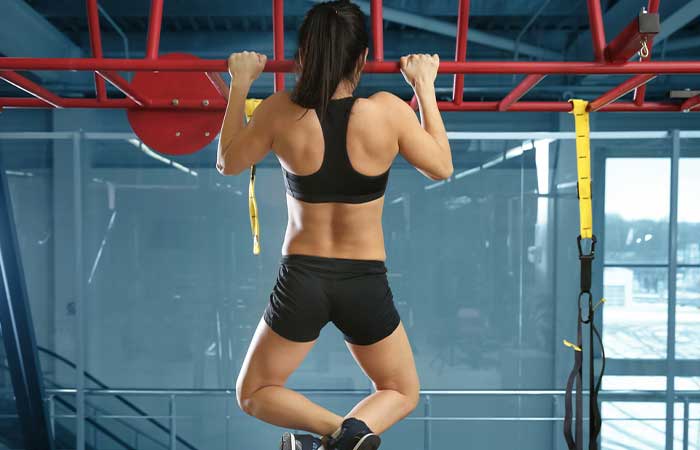 Woman doing horizontal bar pull-ups for EMOM Workouts