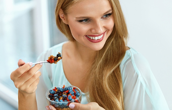 Woman consuming berries to manage psoriasis