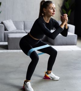 Woman doing closed-chain exercises with resistance band