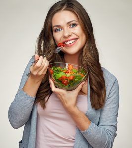 Woman on a fasting mimicking diet holding a vegetable bowl