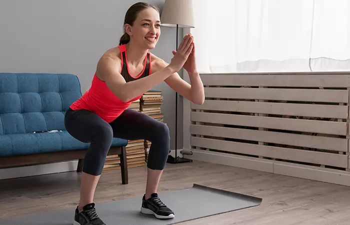Woman performing closed-chain bodyweight squat exercise