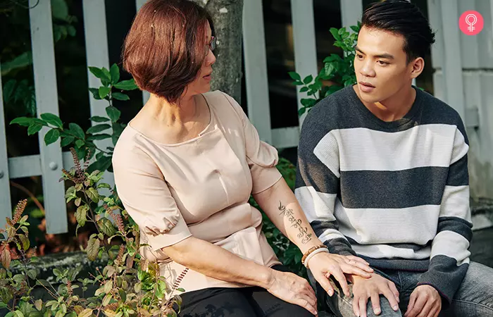 Woman with tibetan chant mother son tattoo on her arm talking to her son