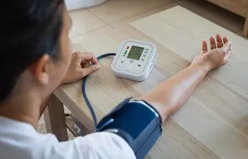 Young woman checking blood pressure after fasting-mimicking diet