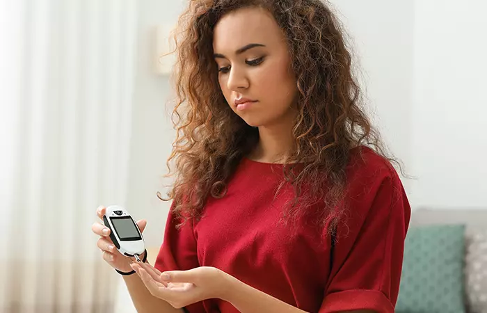 Young woman checking glucose levels after the fasting mimicking diet