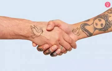 close up of hands of two people with peace mother son tattoo shaking hands