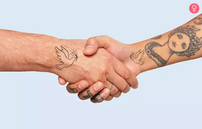 close up of hands of two people with peace mother son tattoo shaking hands