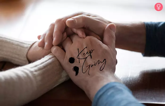 close up of held hands showing semicolon mental health mother son tattoo