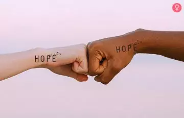 close up of two hands with hope mother son tattoo fist bumping