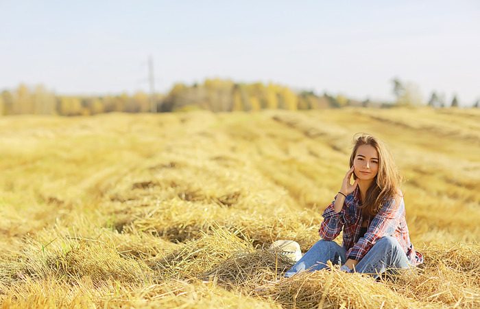 A country girl poses on a field