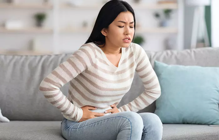 A woman with a stomach ache that may have been caused by constipation due to the Whole30 diet